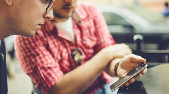 men share news, photos, video on the smartphone. A man shows a f